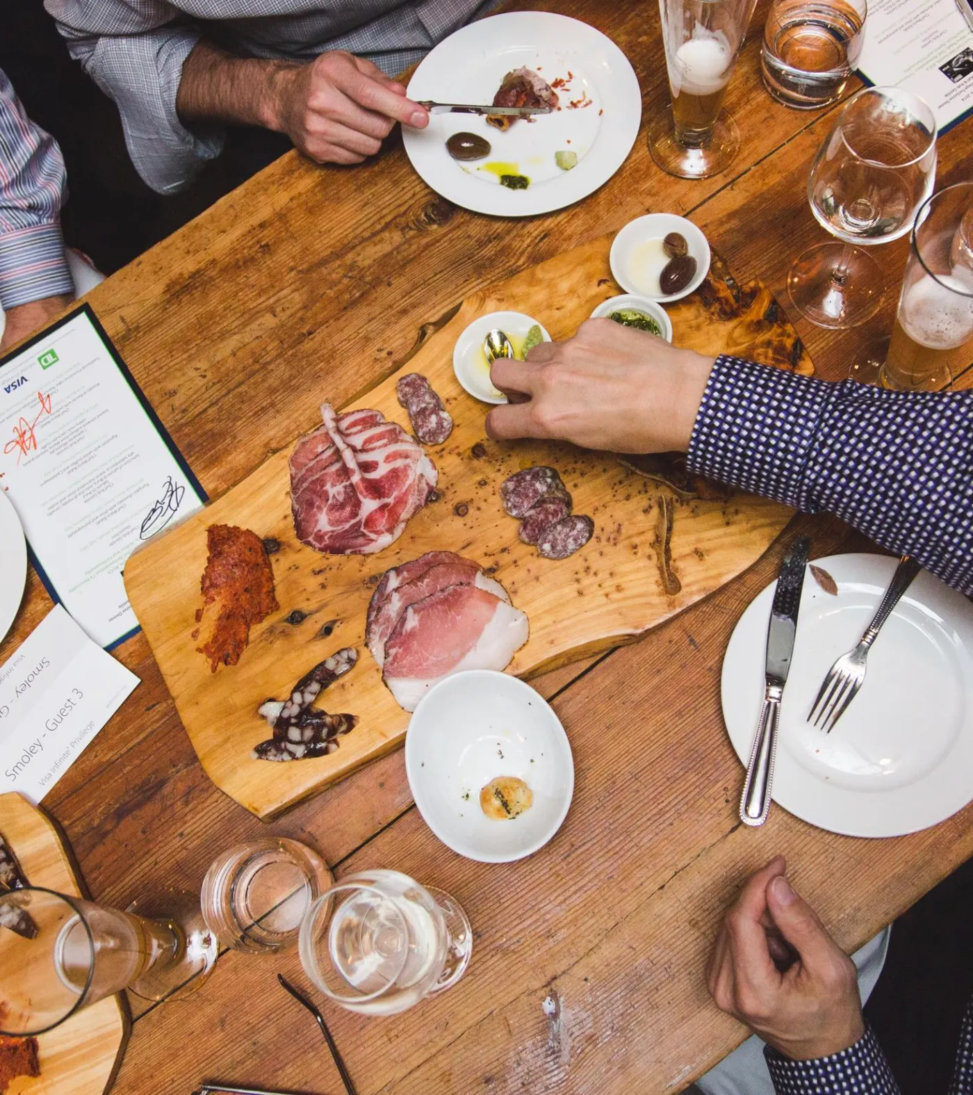 Overhead view of a shared table set with charcuterie and wine